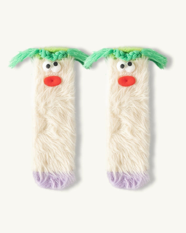 Two plush toy legs with faces, green hair, and red noses on a white background