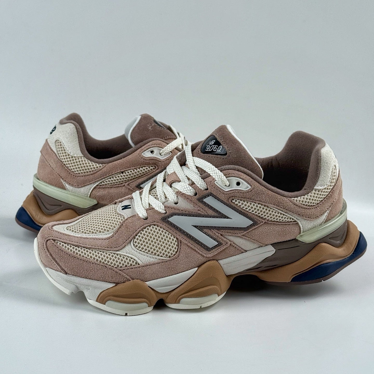 Pair of brown and beige sneakers on a light gray background