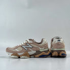 Pair of brown sneakers with white soles on a light gray background