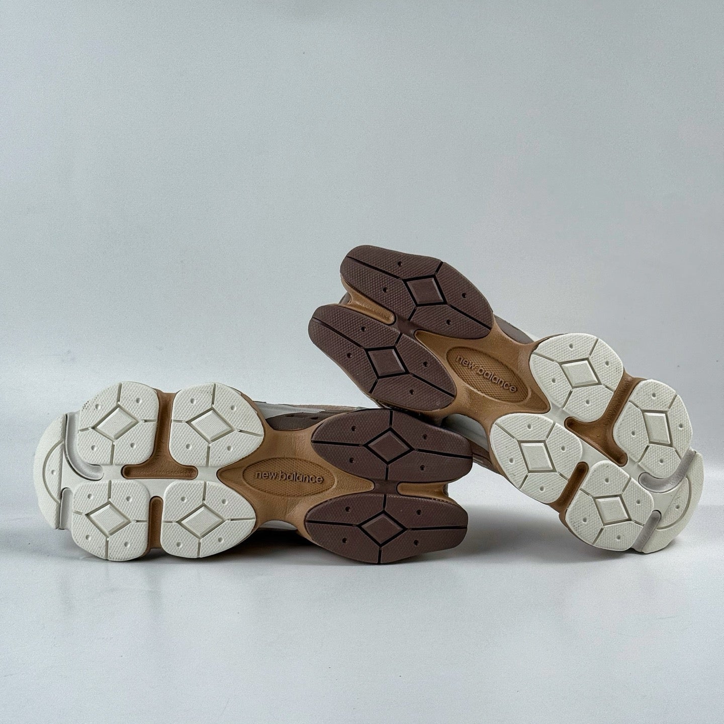 Close-up of three pairs of shoes with soles on a light gray background